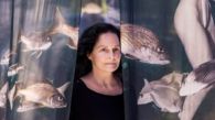 Isabel Muñoz frente a sus fotografías impresas sobre telas flotantes de la exposición ‘Somos agua’ en Casa Mediterráneo - © Miriam Gil Albert.
