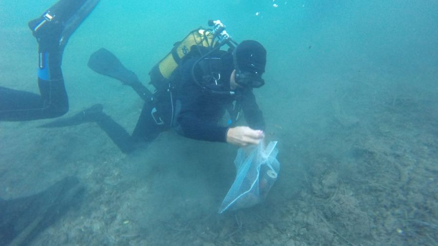 Un buzo recoge residuos del fondo de la bahía de la isla de Nueva Tabarca.